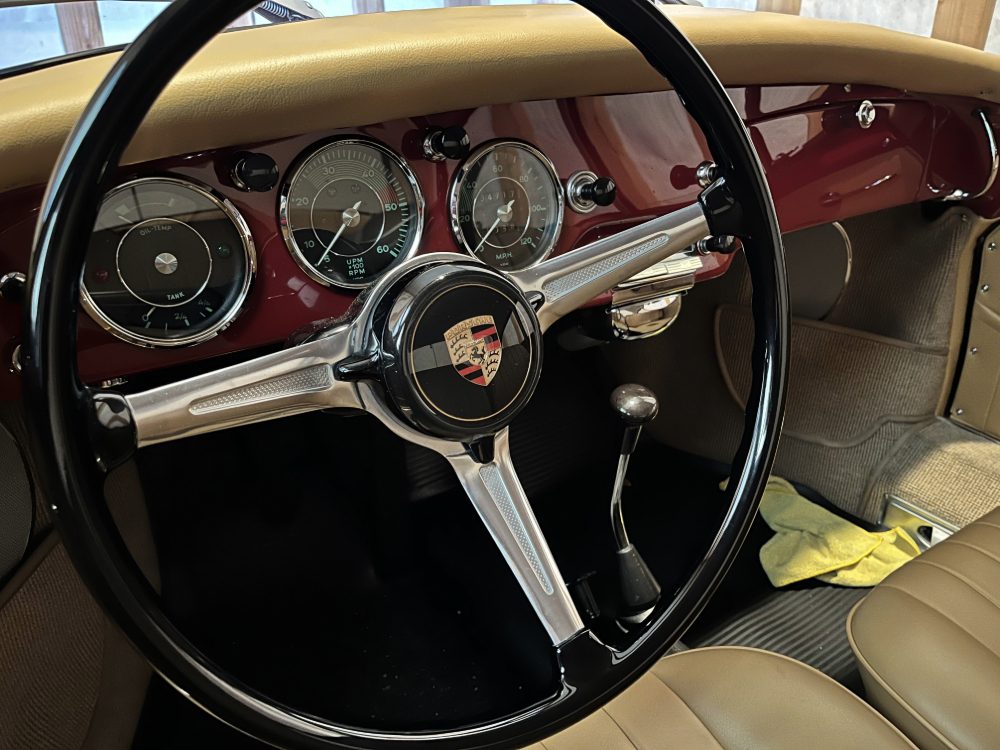 Porsche dashboard seen past the steering wheel, with the instrument cluster in view.